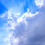 Persona sonriente disfrutando de un café en una mañana nublada, simbolizando un hábito matutino positivo.