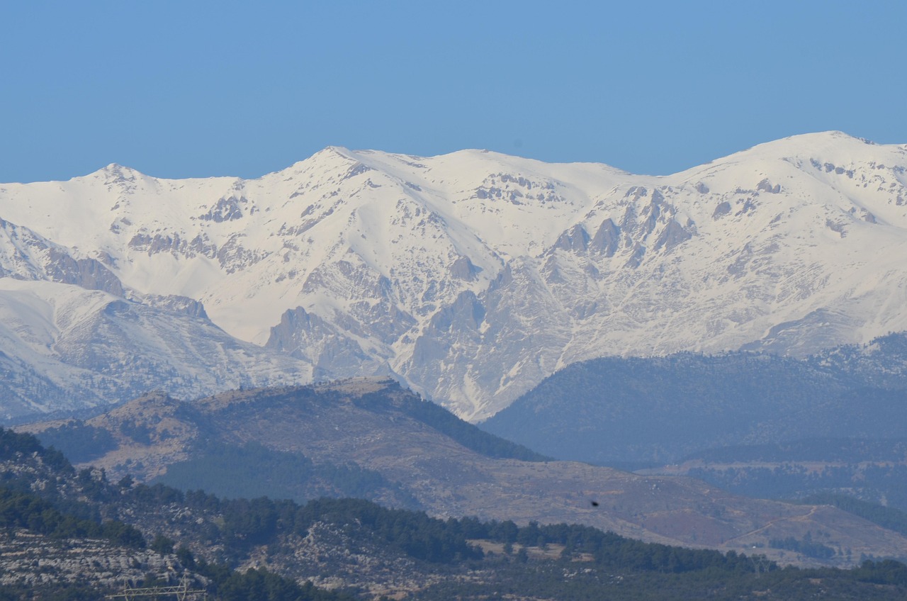 Pueblo con paisajes nevados en Sierra Nevada, mostrando montañas cubiertas di neve.