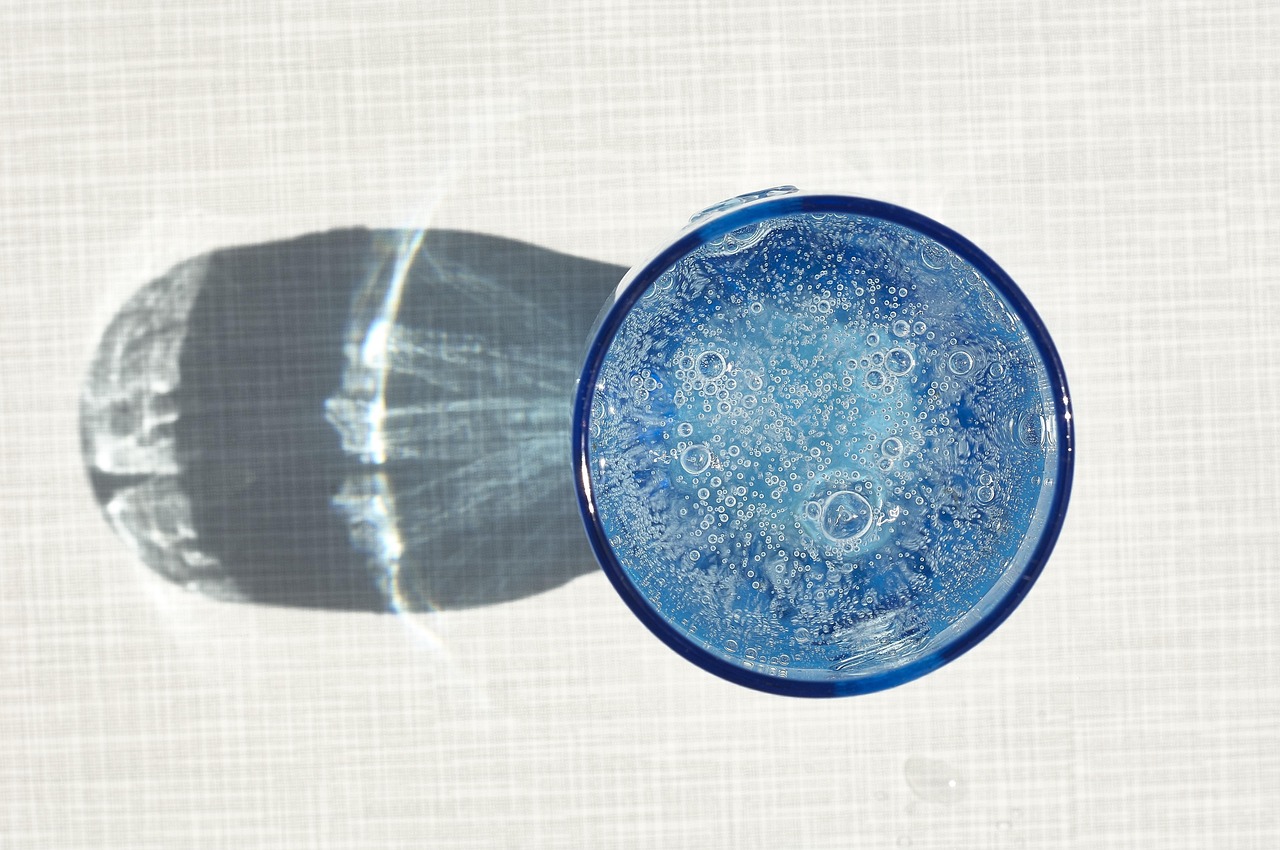 Imagen de un vaso de agua con frutas, simbolizando la hidratación para controlar el azúcar en sangre.